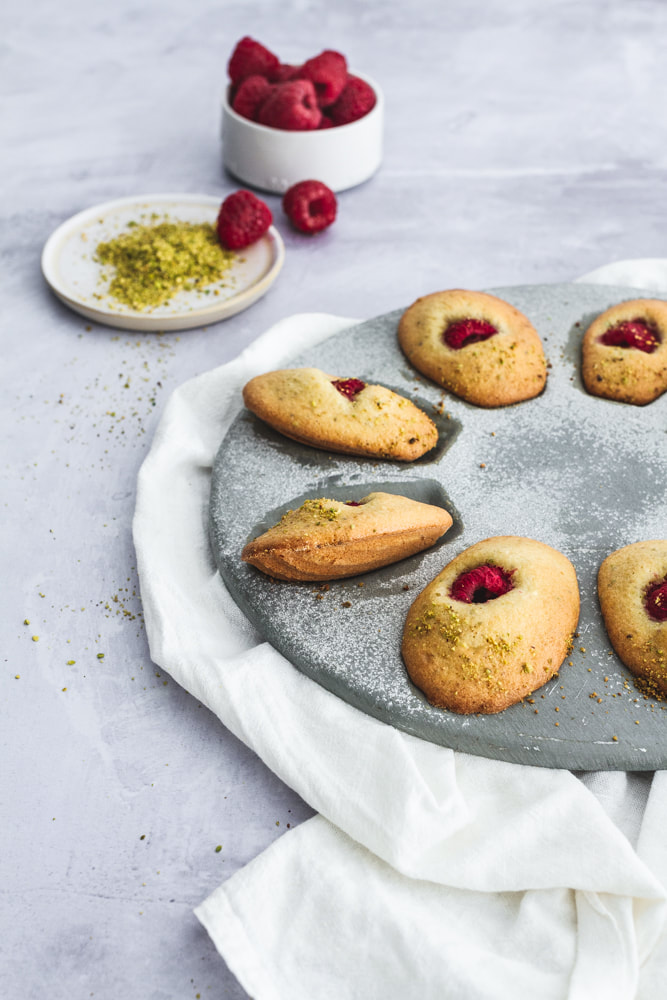 A delicious recipe for raspberry and pistachio madeleines.