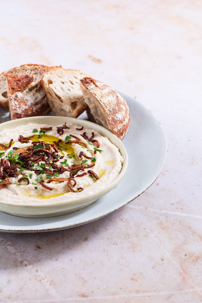A delicious recipe for a dip made with creamy cannellini beans topped with crispy fried shallot